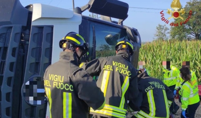 Camion carico di ghiaia si ribalta, autista incastrato nell’abitacolo