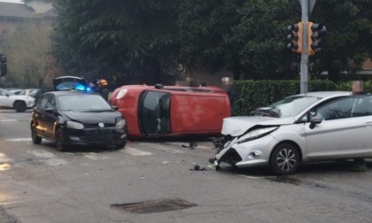 Scontro tra tre auto, una si ribalta: quattro persone ferite in via Lardirago